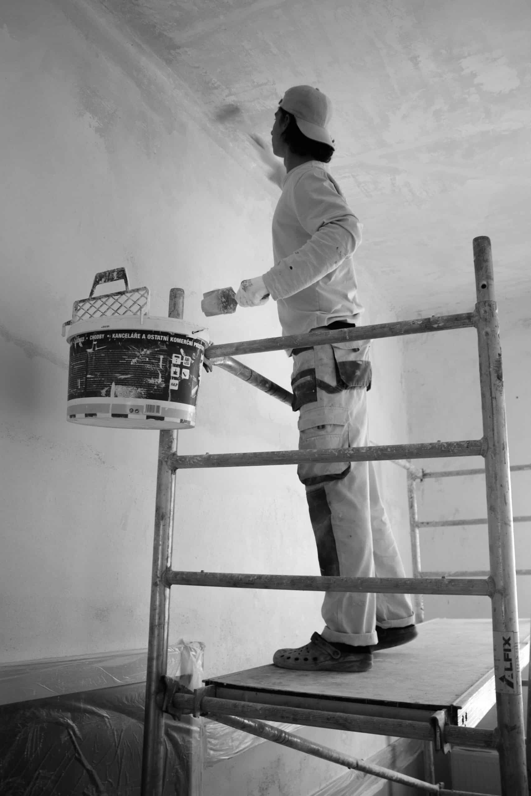Handwerker streicht eine Wand bei der Renovierung nach Mieterwechsel